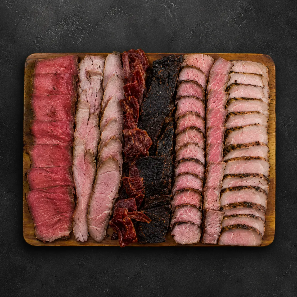 Rectangular 12 by 10 inch wooden meat board with rows of sliced meats